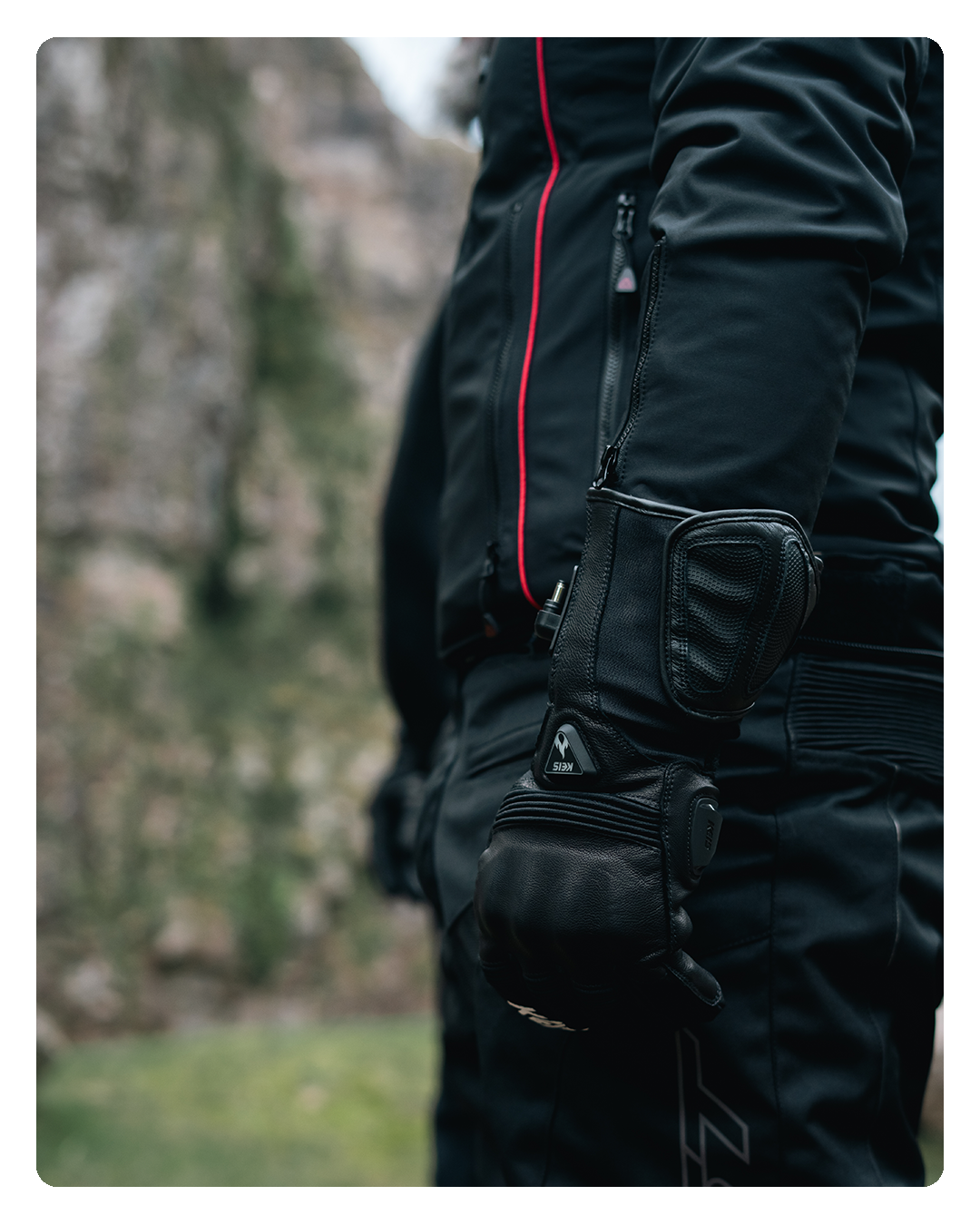 Close-up of the heated glove's gauntlet cuff worn over a jacket sleeve at a rider's side.